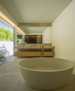 Contemporary minimalist bathroom featuring a freestanding tub, floating vanity, and large window