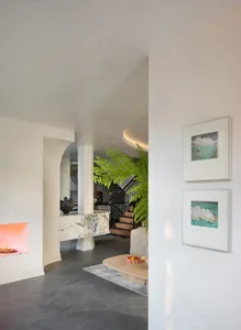 Modern living room featuring marble fireplace and concrete floor.