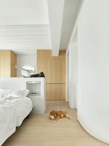 A modern minimalist bedroom with white walls, wooden furniture, and white tiles on the wall.