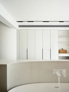 Modern minimalist bathroom design with white ceramic tiles and sleek white fixtures.