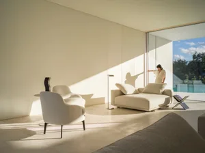 White minimalist living room with modern furniture and floor-to-ceiling windows.