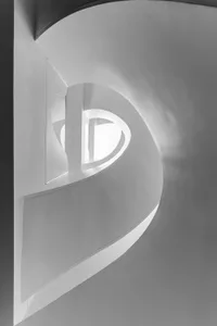 A white, curved architectural space with a window.