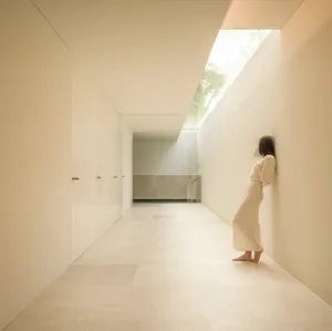 A minimalist interior space with a concrete floor and walls.