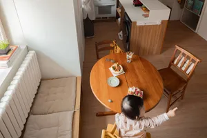 A minimalist kitchen with a solid wood table, chairs, and flooring.