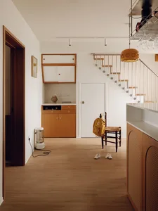 A minimalist residential space featuring wood, metal, and glass materials.