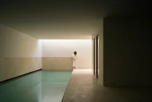 A minimalist swimming pool interior with glass walls and floor.