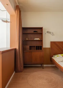 Modern bedroom featuring wooden furniture, including a wooden bed and a wooden bookshelf.