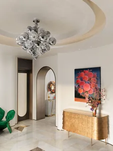 Modern entrance hall featuring a glass pearl chandelier, metallic accents, and a mixed material design with a geometric floor