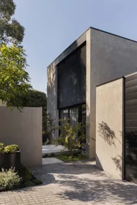 Modern residential entryway featuring concrete and glass materials.
