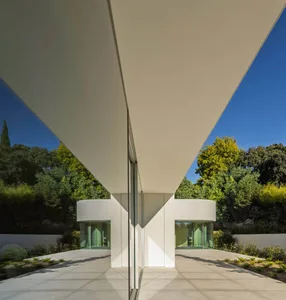 A modern house with white cone-shaped glass panels on a concrete floor.