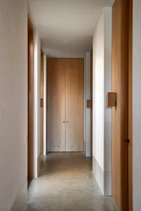 Modern interior design with concrete floor and wooden walls, featuring a minimalist corridor.
