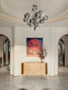 Modern entrance hall with metallic sideboard and abstract floral artwork.