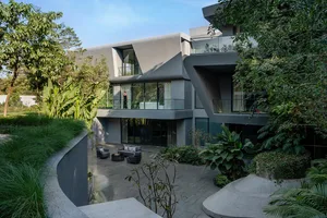 A modern residential living space featuring concrete and glass elements.