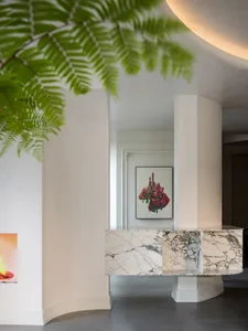 A modern, minimalist living room featuring a large marble slab and contemporary art.