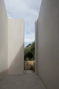 A minimalist architectural design featuring concrete walls and a skylight.