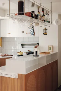 A modern residential kitchen with white countertops, wooden cabinets, and white backsplash.