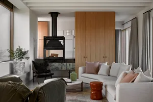 A spacious, modern residential living room with a fireplace and a large sofa.