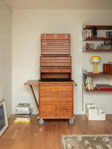 A wooden tool cart with multiple drawers and shelves.