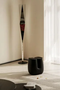 Modern minimalist living room featuring sleek metal and glass furniture.