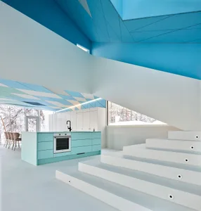A modern kitchen with a concrete staircase and white walls.