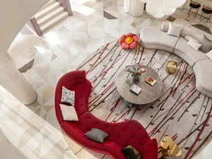 Modern living room with a geometric marble floor pattern, featuring a red curved sofa, a round coffee table, and a grey curve