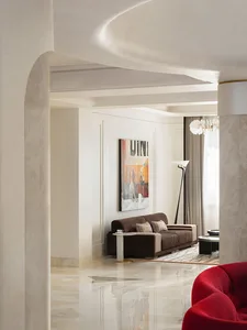 Modern living room with a brown sofa, marble flooring, and a statement artwork on the wall.