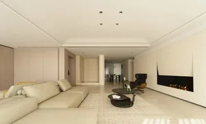 A modern living room featuring a large sectional sofa, a black armchair, and a sleek fireplace.