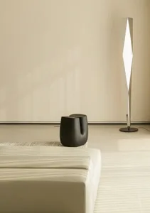 A modern living room with sleek, minimalist decor, featuring a white leather couch and black wooden side tables.
