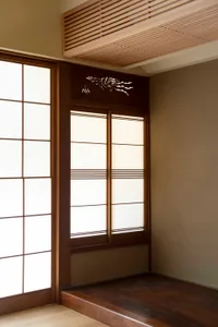 Detailed view of a traditional Japanese sliding door made of wood, featuring a decorative design on the upper part.
