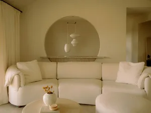 Modern minimalist living room with fabric sofa, marble coffee table, and wooden floor.