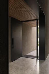 Modern entrance with a metal door and wooden ceiling.