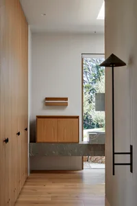 Modern residential entryway featuring wooden cabinets and a marble platform.