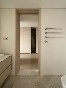 Modern minimalist bathroom with marble flooring and white fixtures.