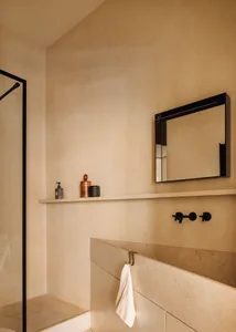 A minimalist bathroom interior featuring concrete and wood elements.