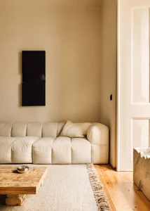 A minimalist living room featuring a white sofa with a textured pattern and a wooden coffee table.