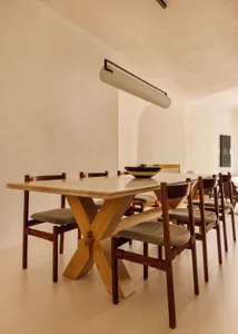 Modern dining room with a marble table and wooden chairs, featuring a minimalist design.