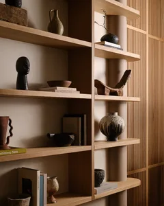 Modern interior design featuring a wooden shelving unit with various decorative items and books.