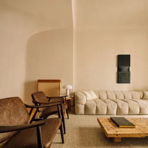 A textured living room featuring a comfortable sofa with neutral tones and a wooden coffee table.