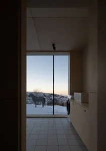 A minimalist interior design featuring a wood floor and floor-to-ceiling window.