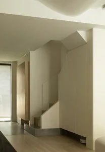 現代住宅室內採用極簡設計，搭配混凝土地板、木質家具與玻璃扶手。