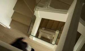 A modern interior space with a glass staircase.
