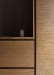 Wooden kitchen storage unit with a small concrete vase on top.