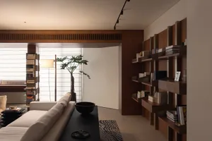 A modern minimalist living room featuring wood accents and a clean, organized space.