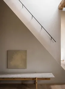 A modern staircase with a concrete tread, wooden risers, and stone steps.