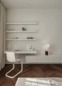 A minimalist home office featuring a floating desk, wooden shelves, and a white chair.