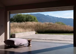 A minimalist residential exterior featuring concrete surfaces and grassy landscaping.