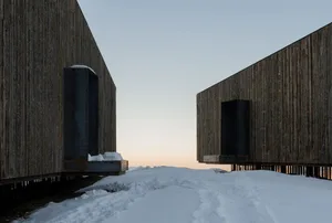 Modern architectural structures with snow-covered exterior and steel elements.