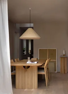 A modern dining room with wooden furniture and a large pendant light hanging above the table.