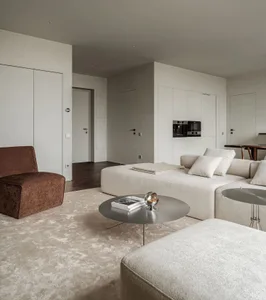 Modern living room with a minimalistic design featuring a taupe, ecru, white, and grey color scheme.