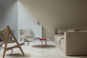 A minimalist industrial living room with a modern sofa, armchair, and coffee table.